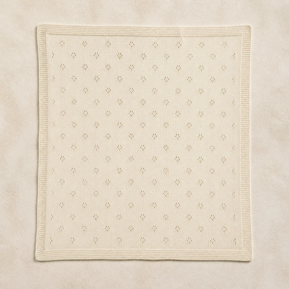 Elfenbeinfarbene Babystrickdecke mit Ajourmuster